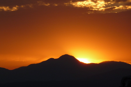 mountains with sun setting behind them